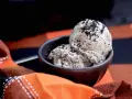 Zwei Kugeln cremiges **black sesame ice cream** in einer Schale, bestreut mit schwarzen Sesamsamen, auf einem karierten Stoff.