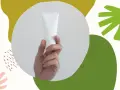 Dłoń trzyma białą tubkę kosmetyku. Czy zawiera alkohol denat w kosmetykach? Abstrakcyjne kształty w tle.