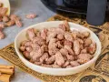 Schüssel mit gerösteten Mandeln, die mit Zimt und Zucker bestreut sind. Ein gesunder Snack, der gut schmeckt.