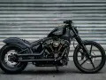 Czarny, klasyczny motocykl Harley-Davidson z błyszczącym lakierem i złotymi akcentami na silniku, gotowy na drogę.