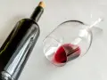 Ciemna butelka i przewrócony kieliszek z czerwonym winem. Idealny wieczór z winem półwytrawnym.