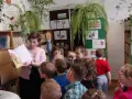 Nauczycielka czyta dzieciom książkę, tworząc inspirujące lekcje biblioteczne scenariusze. Dzieci słuchają z uwagą.