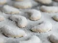 Zarte Vanillekipferl, mit Puderzucker bestäubt, warten darauf, genossen zu werden.