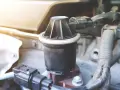 Dettaglio di un componente del motore, la valvola EGR, con connettori elettrici e tubi nelle vicinanze.