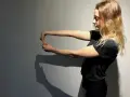 Jeune femme faisant un étirement du poignet, geste clé pour la rééducation de l'épitrochléite et réduire le temps de guérison.