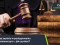 Sędzia uderza młotkiem, symbolizując wydanie nakazu zapłaty w postępowaniu upominawczym. Obok stos starych ksiąg prawnych i wagi sprawiedliwości.