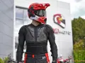 Motocyklista w kasku i ochraniaczach. Kurtka z membraną chroni przed wiatrem i deszczem, zapewniając komfort.