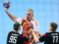 Gracz MKS Piotrkowianin z piłką w ręku, otoczony przez obrońców.