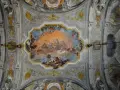 Plafond orné de fresques célestes, un exemple de style **rococo def.**, avec des anges, des chevaux et un soleil éclatant.