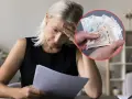 Zmartwiona kobieta z dokumentami i ręką trzymającą pieniądze, sugerujące problemy z przestępstwami podatkowymi.