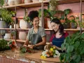 Deux fleuristes souriantes créent des bouquets. Un métier artistique bien payé qui embellit le quotidien.