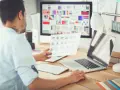 UX designer analizuje wydruki i ekran komputera z paletą barw.