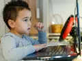 Chłopiec z zaciekawieniem ogląda na laptopie materiały o biologii dla dzieci.