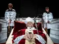 Papież w stroju, z różańcem, leży w trumnie. Obok stoją dwaj mężczyźni w białych szatach. Czy to bluźnierstwo, co to?