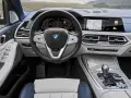 Wnętrze BMW X7: kierownica, ekran multimedialny z nawigacją i muzyką, panel klimatyzacji, dźwignia zmiany biegów.