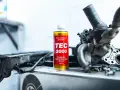 TEC 2000 płukanka do wtryskiwaczy obok rozebranego silnika.