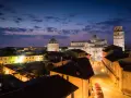 Magnifique paysage de Pise au crépuscule, avec la cathédrale, le baptistère et la tour penchée illuminés. Une belle photographie de paysage.