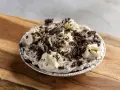 Pyszna masa oreo do tortu, udekorowana bitą śmietaną i pokruszonymi ciasteczkami. Idealna na deser!