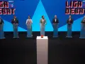 Siedmiu mężczyzn w garniturach stoi za mównicami. W tle logo "Liga Debat #2".