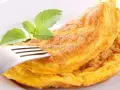 Puszysty omlet z piekarnika, złocisty i lekki, z gałązką bazylii. Idealny na śniadanie.