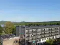 Widok na hotel Solina Resort & Spa z apartamentami i pokojami, otoczony zielenią, z jeziorem Solina w tle.