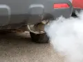 Fumata bianca auto esce dal tubo di scarico, creando una nuvola densa che si disperde nell'aria.