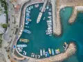 Widok z lotu ptaka na port z wieloma łodziami i jachtami. Widać też drogę z samochodami i budynki. To idealne miejsce na wakacje, a ceny na Cyprze mogą być atrakcyjne.