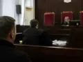 W sali sądowej mężczyzna czeka na rozprawę. Ile trwa sprawa karna?