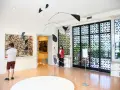 Un uomo ammira un quadro astratto, mentre una donna osserva una scultura mobile. Un'atmosfera d'arte al Peggy Guggenheim di Venezia.