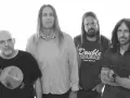 Czterech muzyków Steel Panther w Warszawie: łysy w czarnej koszulce, długowłosy w jasnej koszuli, z brodą w koszulce "Double Deuce" i w dżinsowej koszuli.