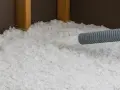 Installazione di isolamento soffiato, simile alla lana di roccia o lana di vetro, in una struttura in legno.