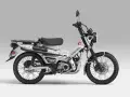 Srebrny motocykl Honda CT 125 z czarnym siedzeniem i bagażnikiem, gotowy na przygodę.