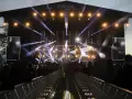 Jarocin Festiwal rozświetlony tysiącami świateł. Tłum czeka na koncert, a na scenie widać artystów.