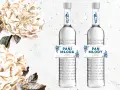 Dwie butelki polskiej wódki "Pan Tadeusz" z etykietami "Pani Młoda" i "Pan Młody", ozdobione kwiatami.
