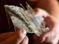 Hände halten ein Stück Gelatine, das wie Glas zerbrochen ist. Die feinen Linien zeigen die vielfältige Gelatine Verwendung in der Küche.
