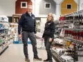 Två anställda står i en butik med färg och verktyg. De hjälper dig gärna att välja rätt färg för att måla fasad.