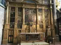 The ornate altar of the Basilica of Mary Magdalene features a central crucifixion scene surrounded by smaller narrative paintings, all set within a gilded structure.
