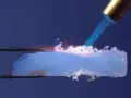 Un pezzo di aerogel, materiale innovativo per l'edilizia, viene riscaldato con una fiamma.