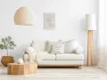Jasny salon, gdzie kolor biały oznacza spokój i czystość. Sofa, lampa i zasłony tworzą harmonijną całość.