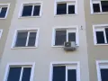 Klimatyzacja w bloku, zamontowana na ścianie między oknami, zapewnia komfort mieszkańcom.