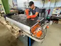 Mechaniker arbeitet an einer großen Batterieeinheit, die für Elektroautos bestimmt ist. Dies ist wichtig für die **Autobatterie Garantie**.