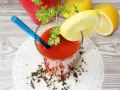 Orzeźwiający drink z sokiem pomidorowym, ozdobiony plasterkiem cytryny i natką pietruszki, gotowy do wypicia.