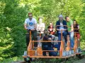 Rodzina na drezynach w Bieszczadach, ciesząca się zielenią i słońcem. Radość i wspólna przygoda na torach.