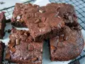 Saftige Zucchini Brownies mit Schokostückchen, die auf einem Gitterrost liegen.