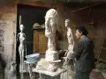 Alberto Giacometti w pracowni, otoczony swoimi charakterystycznymi, smukłymi rzeźbami i niedokończonymi formami.