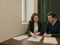 Dos personas revisan documentos en una mesa. Podrían ser ejemplo dos pagadores de renta discutiendo un contrato.