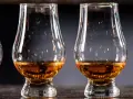 Drei Gläser mit bernsteinfarbenem Whisky stehen nebeneinander. Ein Blick auf die Whisky Kalorien für Genießer.