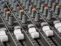 Regler und Fader eines Mischpults, bereit, um zu lernen, wie man Musik mixt.