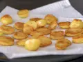 Patatas al horno doradas y crujientes, recién salidas del horno y reposando sobre papel absorbente. ¡Un manjar listo para disfrutar!