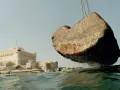 Un bloc de pierre, vestige du phare d'Alexandrie, est soulevé au-dessus des eaux, près de la citadelle de Qaitbay.